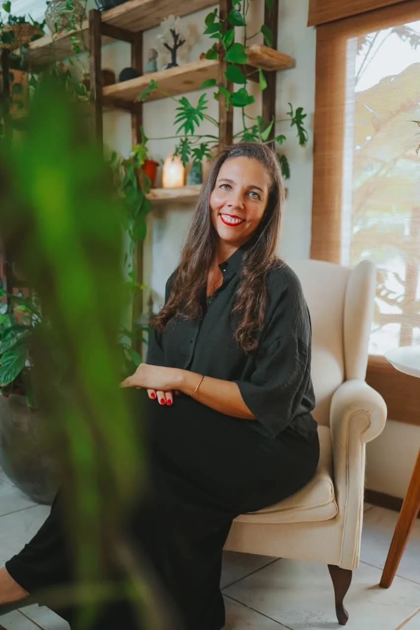 Andreia Simões Pires Weiler sentada em um ambiente cercado por plantas